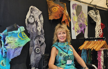 An artist in her booth of hand-felted wearable art at a Sarasota art show
