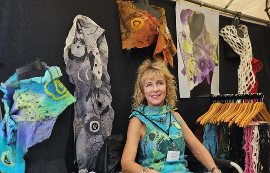 An artist in her booth of hand-felted wearable art at a Sarasota art show