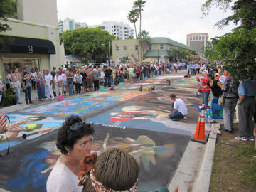 Crowds walking a downtown street covered in chalk paintings at the 2011 Sarasota Chalk Festival