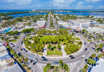 Aerial view of St. Armands Circle in Sarasota, Florida, with the palm-lined center park, shops and Sarasota Bay